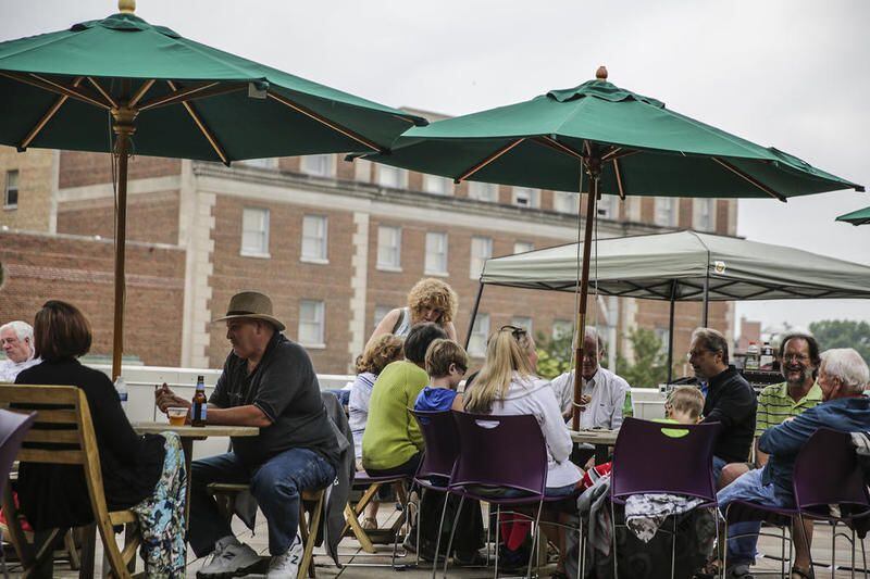 People lounge of the rooftop deck at the Joliet Area Historical Museum for a summer concert.