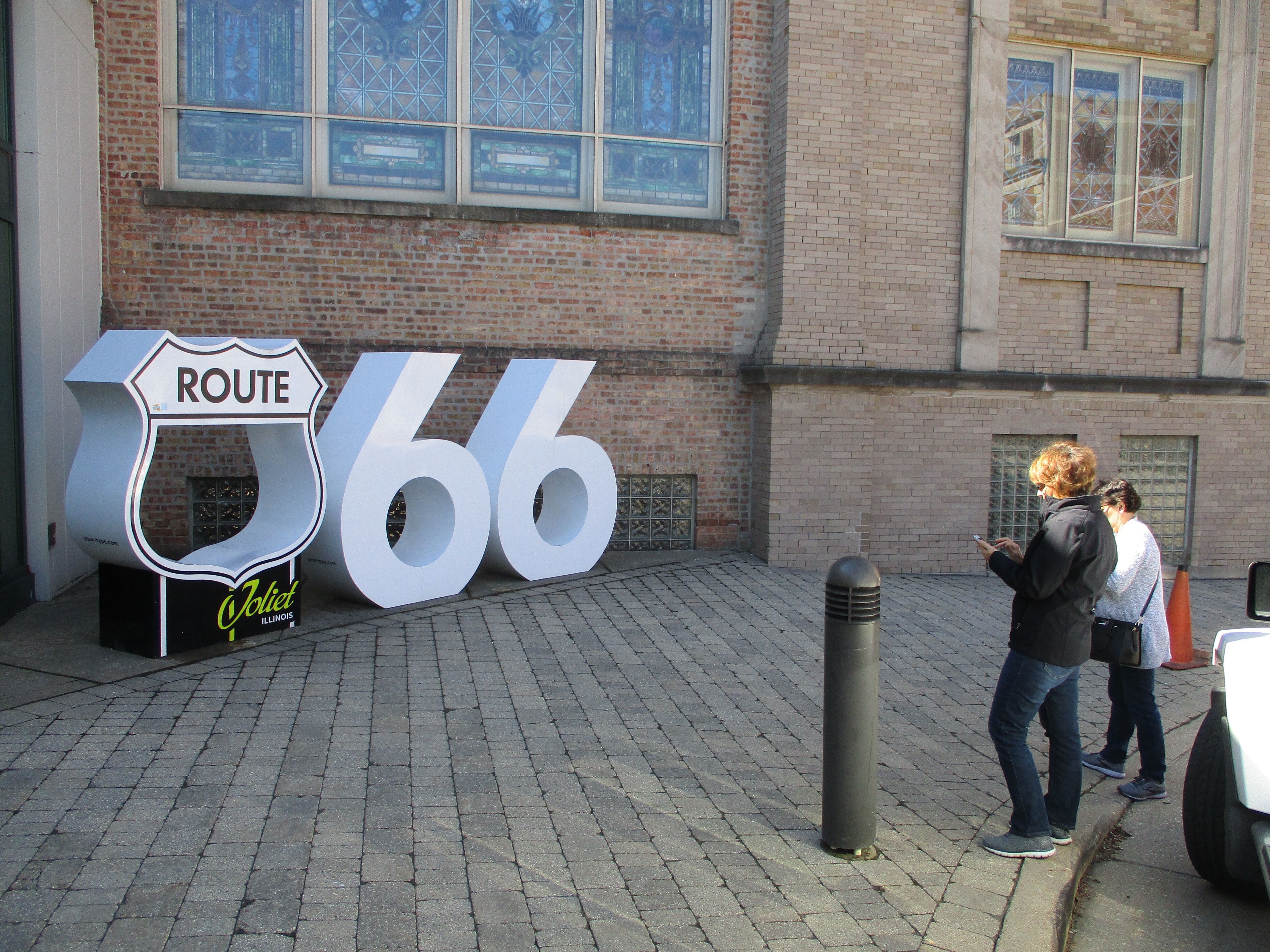 Participants in the Route 66 Red Carpet Corridor Festival check out a Route 66 sculpture outside the Joliet Area Historical Museum on Saturday, May 7, 2022.