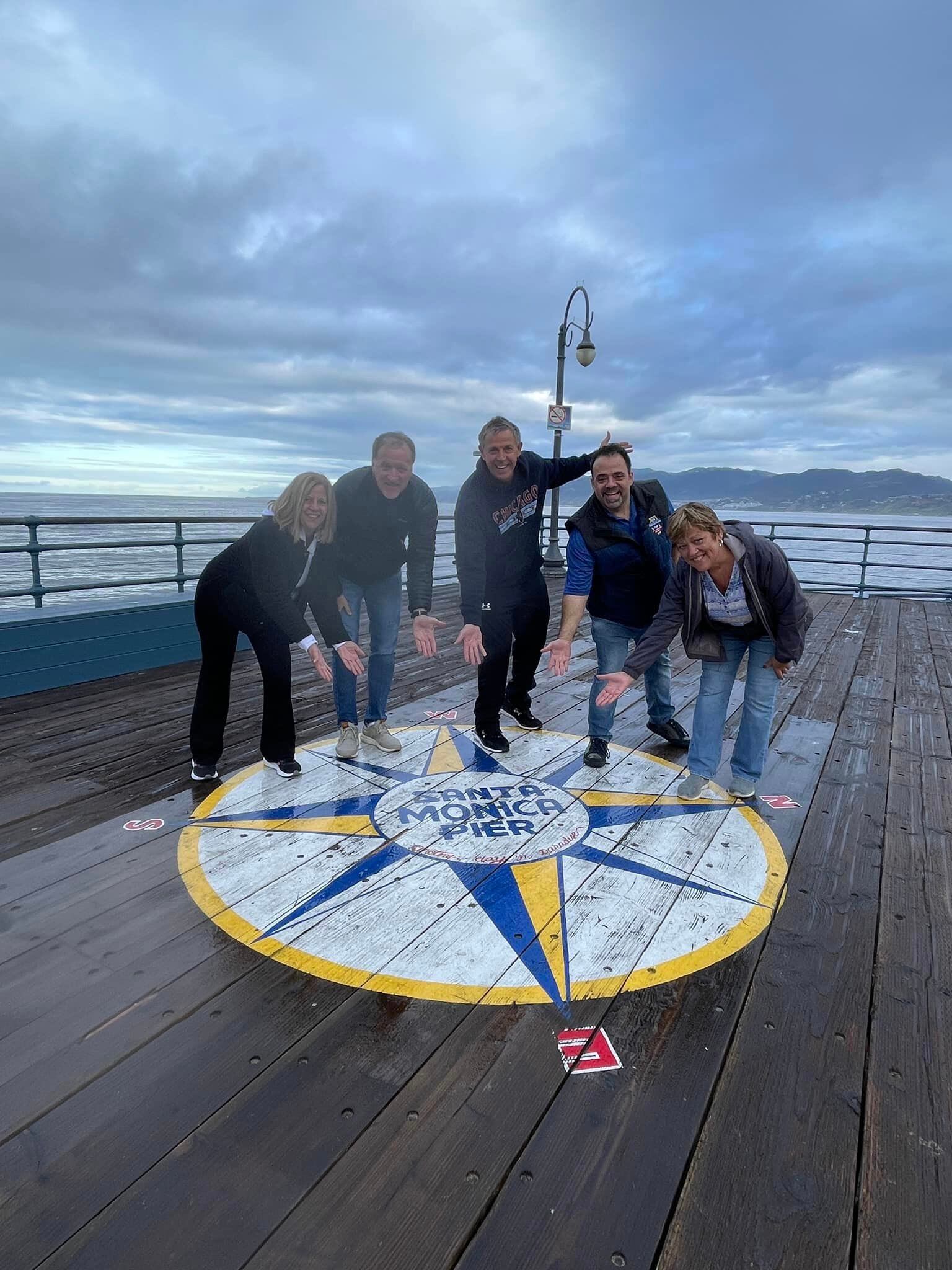 A can't miss photo-op at the end of the pier as the sun begins to peek through the early morning clouds in Santa Monica, CA.